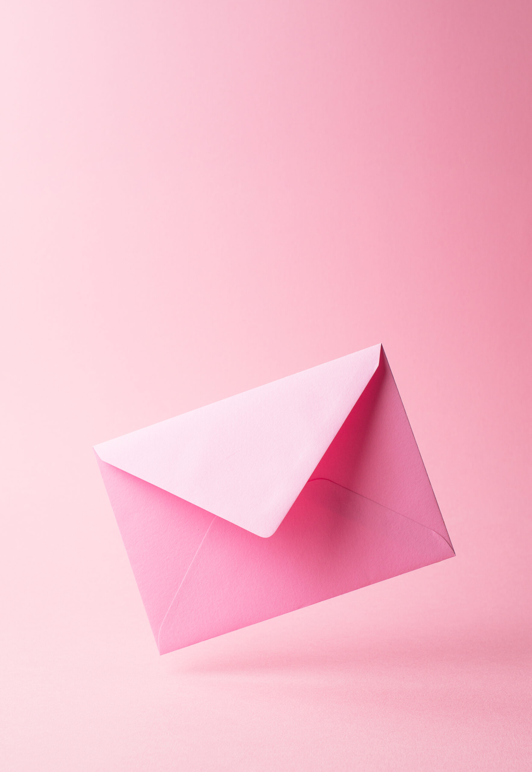 Pink envelope dropped over pink background